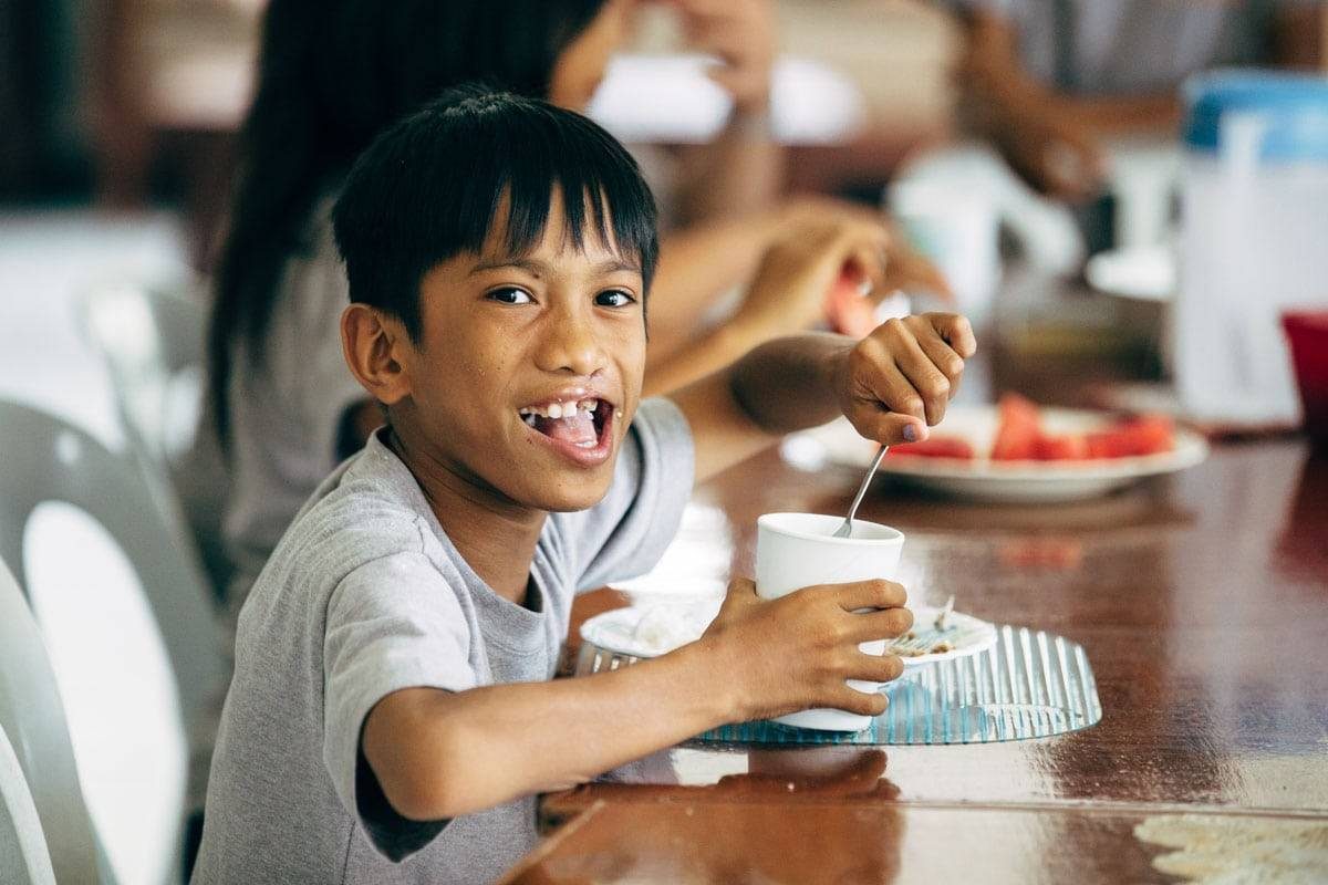 Young boy eating at a table.