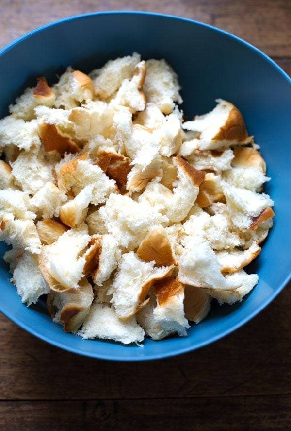 Pieces of bread in a blue bowl.