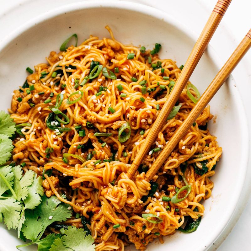 Bowl of gochujang noodles with chopsticks.