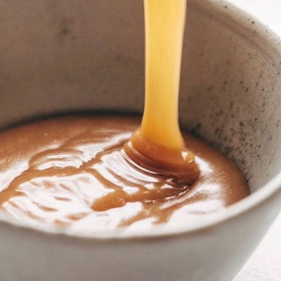 Vegan Caramel Sauce poured into a bowl.