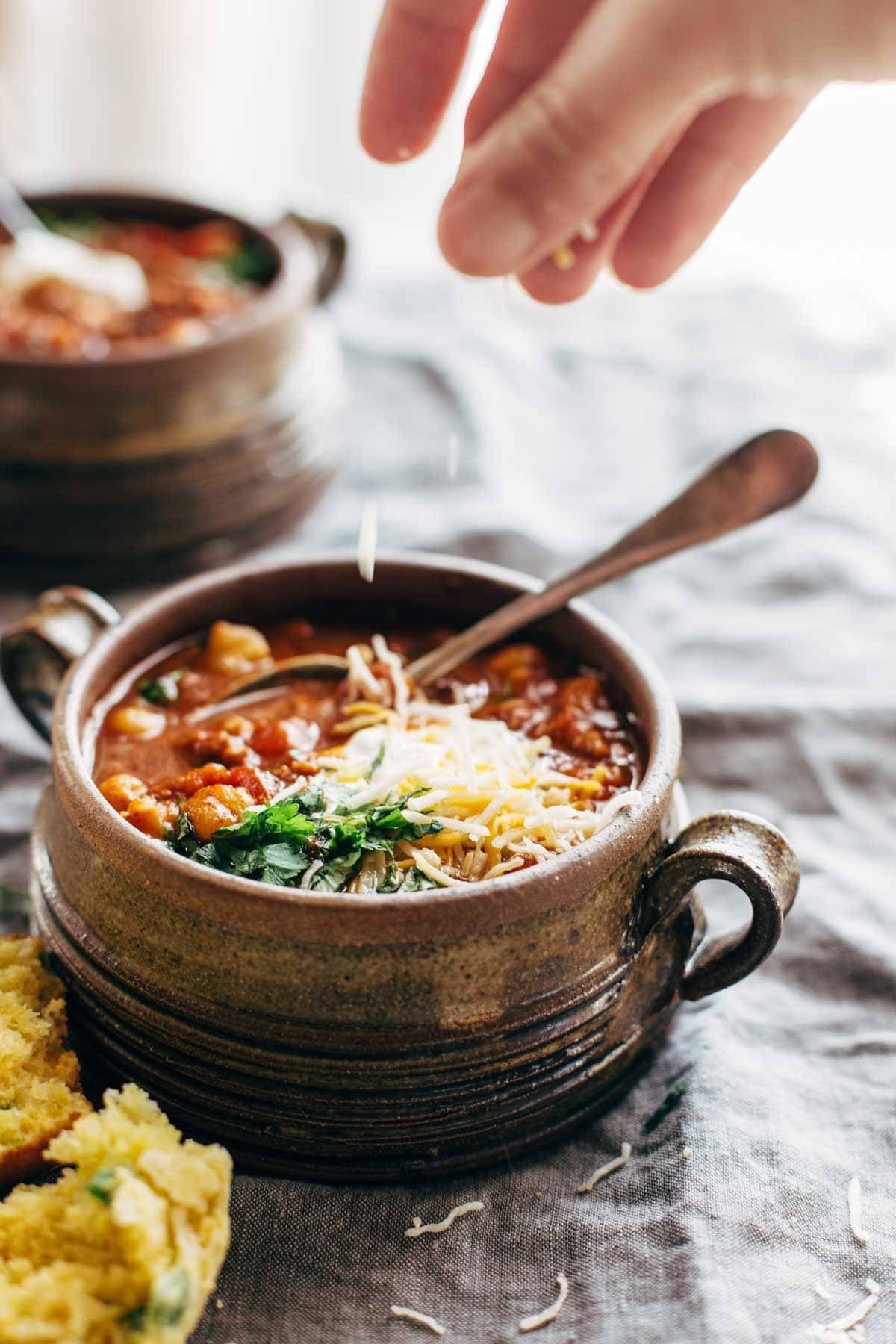 Spicy Posole with cheese topping and with Cheesy Jalapeño Cornbread Muffins.