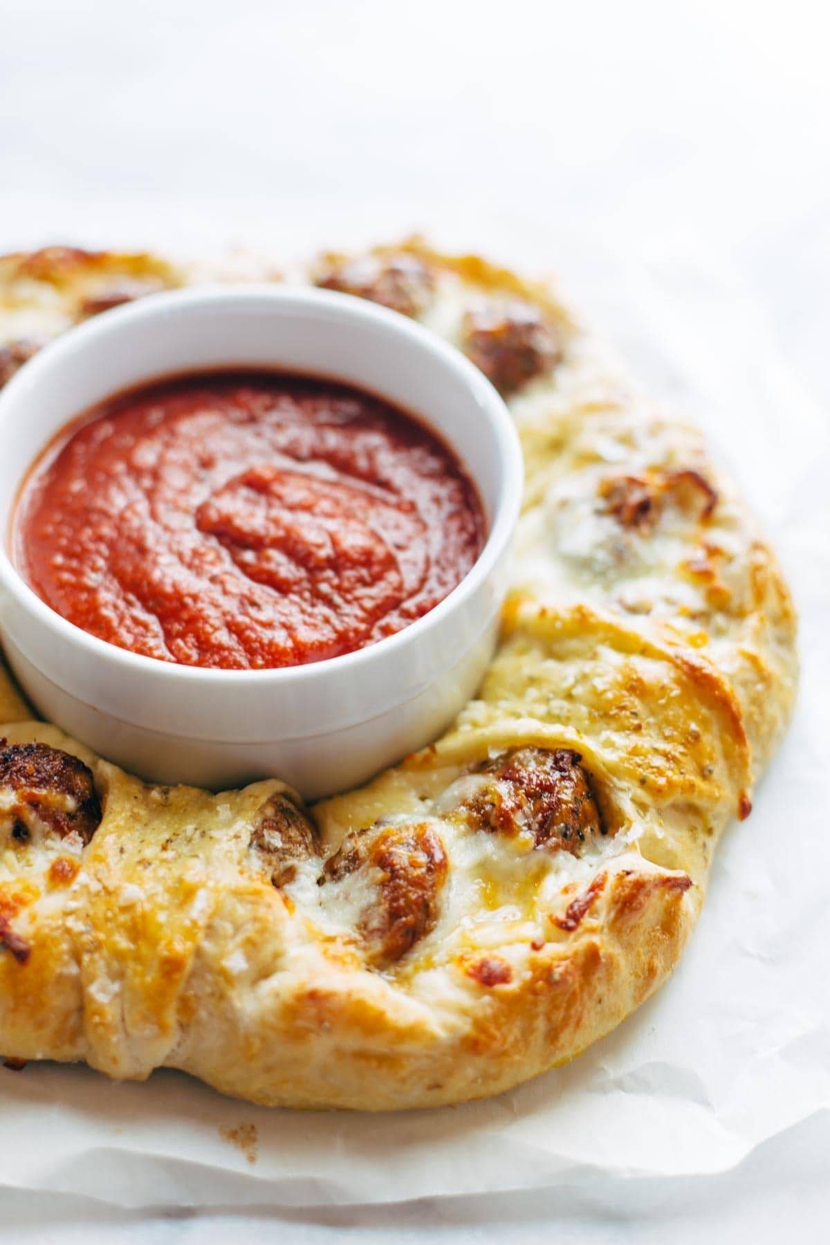 Cheesy Meatball Pull-Apart Pizza Ring with a bowl of marinara sauce