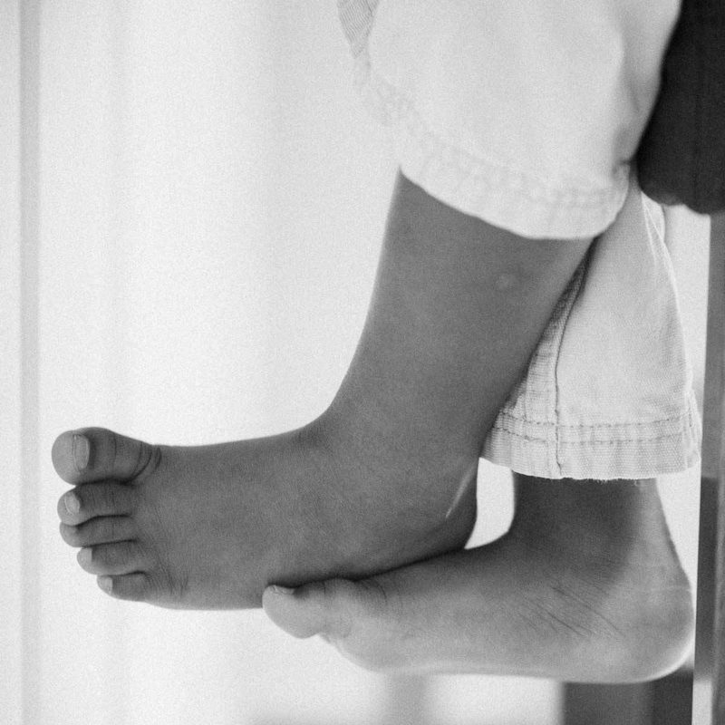 Feed of a child sitting on a table.