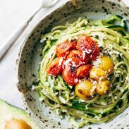 Zucchini spaghetti with tomato topping in a bowl.