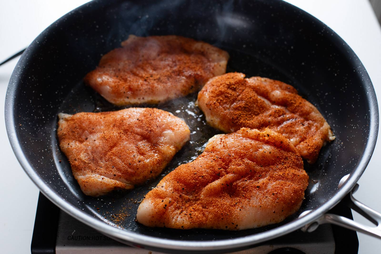 Sauteing chicken in a skillet.