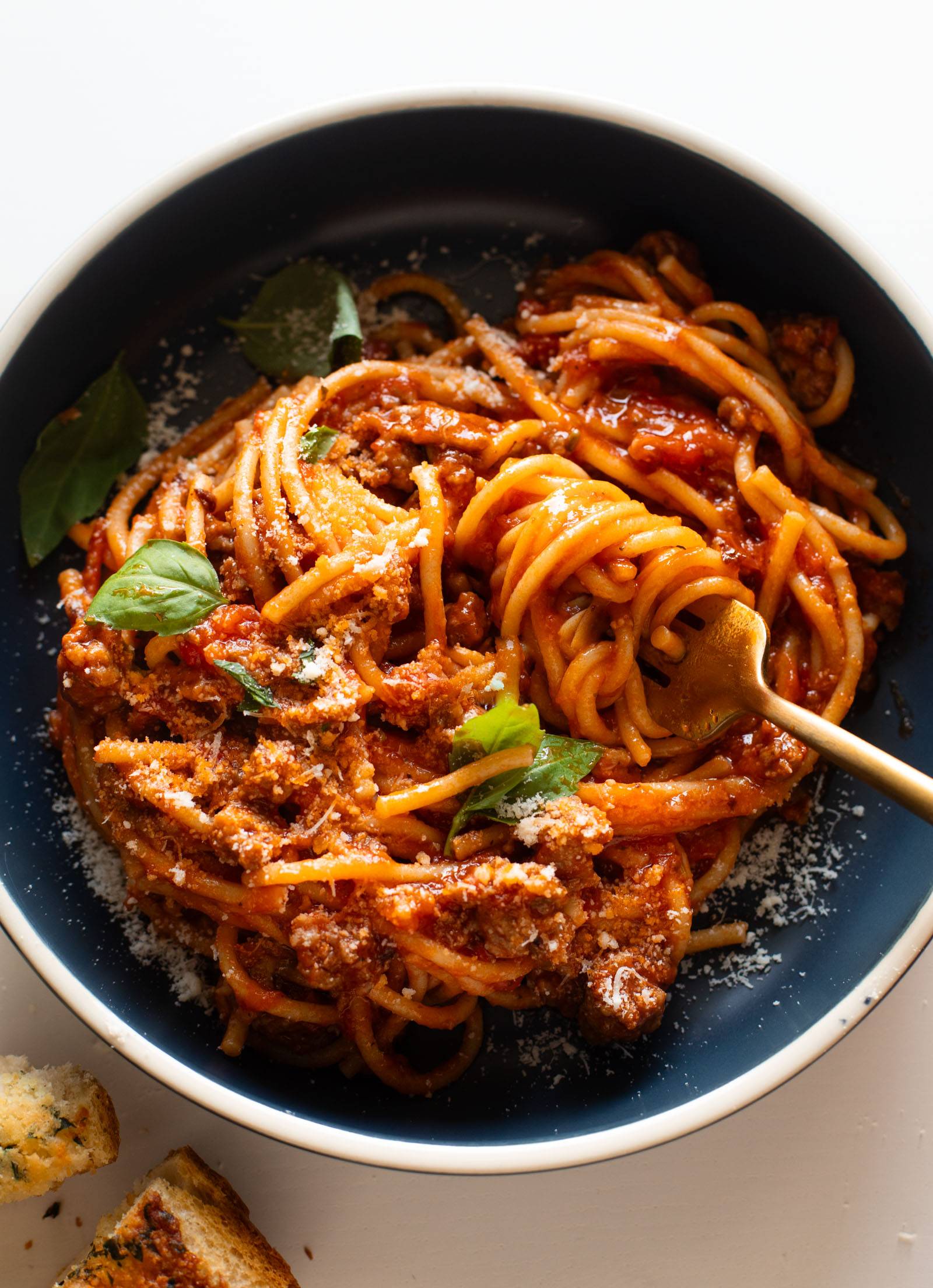 Instant Pot Spaghetti in a bowl topped with basil and parmesan.