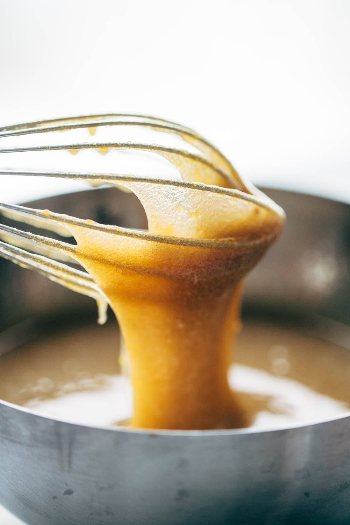 Lemon Poppyseed Zucchini Bread batter in a bowl and on a whisk.