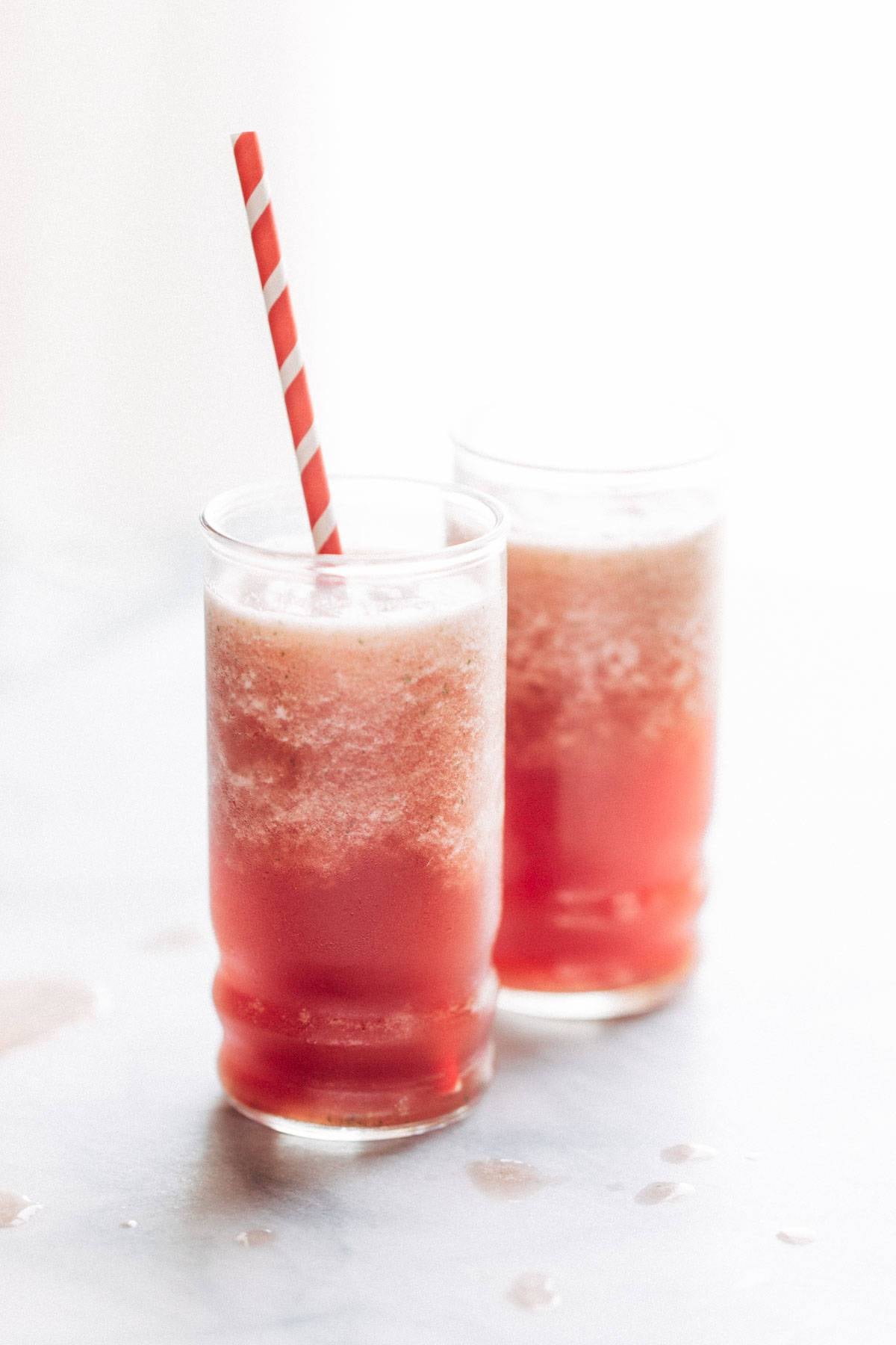 Watermelon smoothies with a straw.